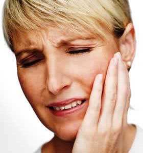 A woman grabbing her face in pain.