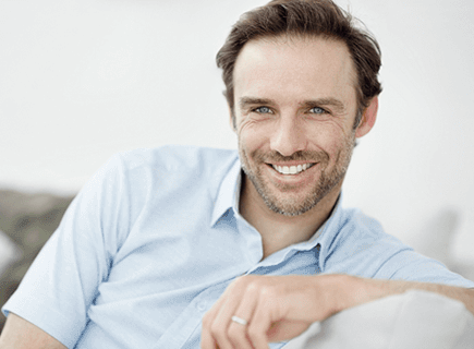 Brunette man with shadow beard smiling - perhaps after receiving cater-to-cowards dentistry