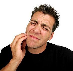 man holding his jaw in pain
